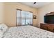 Bedroom with hardwood flooring, ceiling fan, a comfortable bed, and a window for natural light at 11009 Wildcat Dr, Riverview, FL 33579