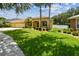 Well-maintained home with a three-car garage, manicured lawn, and lush landscaping at 11009 Wildcat Dr, Riverview, FL 33579