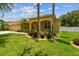 Beautifully landscaped front yard with manicured bushes, palm trees, and a well-maintained lawn at 11009 Wildcat Dr, Riverview, FL 33579