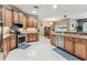 Open kitchen features wooden cabinets, stainless steel appliances, and tile flooring at 11009 Wildcat Dr, Riverview, FL 33579