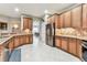 Spacious kitchen with wood cabinets, stainless steel refrigerator, and tile backsplash at 11009 Wildcat Dr, Riverview, FL 33579