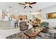 Open living area with seating, a ceiling fan, and tile flooring that connects to the kitchen and dining area at 11009 Wildcat Dr, Riverview, FL 33579