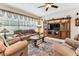 Comfortable living room featuring a plush sofa, armchairs, ceiling fan, and a wooden entertainment center at 11009 Wildcat Dr, Riverview, FL 33579