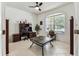 Well-lit home office with tiled floor and a large window overlooking the front yard at 11009 Wildcat Dr, Riverview, FL 33579