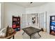 Home office with French doors, built-in shelving, and neutral tile flooring at 11009 Wildcat Dr, Riverview, FL 33579