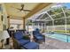 Covered patio boasts wicker furniture, a ceiling fan and views of the enclosed pool and fenced yard at 11009 Wildcat Dr, Riverview, FL 33579