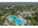 Aerial view of a large community pool with cabana and lounge chairs surrounded by mature tropical trees in a lush neighborhood at 11009 Wildcat Dr, Riverview, FL 33579