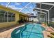 Inviting screened-in pool area with patio furniture and a well-maintained brick deck at 11009 Wildcat Dr, Riverview, FL 33579