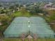 Aerial view of a well-maintained tennis court facility surrounded by lush greenery, providing an excellent space for recreational play at 11009 Wildcat Dr, Riverview, FL 33579