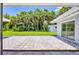 Inviting backyard patio with white stone landscaping and a view of the lush green lawn and palm trees at 116 Myakka Dr, Venice, FL 34293