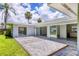 A charming backyard patio with decorative stone is adjacent to a lush green lawn and bright home exterior at 116 Myakka Dr, Venice, FL 34293