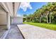 Spacious backyard featuring a concrete patio with decorative white stone and access to the lawn with palm trees at 116 Myakka Dr, Venice, FL 34293