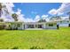 Expansive backyard featuring sliding glass doors and a cozy patio, all surrounded by a well-maintained lawn at 116 Myakka Dr, Venice, FL 34293