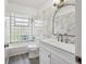 Modern bathroom featuring marble tiled walls, sleek fixtures, and a glass block window for natural light at 116 Myakka Dr, Venice, FL 34293