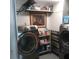 Efficient laundry room with modern, gray washing machines and storage at 1209 Croydonwood Cir, Brandon, FL 33510
