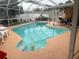 Screened-in swimming pool area with clear water, patio space, and tropical landscaping at 1209 Croydonwood Cir, Brandon, FL 33510