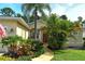 Charming home featuring a well-manicured lawn, tropical plants, and inviting walkway to the front door at 12113 Whistling Way, Lakewood Ranch, FL 34202