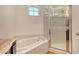 Relaxing main bathroom showcases a soaking tub, glass-enclosed shower, and modern fixtures at 12113 Whistling Way, Lakewood Ranch, FL 34202