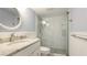 This bathroom features a granite countertop vanity and a glass door shower with decorative stone flooring at 1257 S Portofino Dr # 306, Sarasota, FL 34242