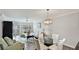Bright living and dining space with a chandelier, comfortable seating, and balcony access at 1257 S Portofino Dr # 306, Sarasota, FL 34242