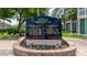 Community sign with building directories, flags, and attractive landscaping enhancing the overall appeal at 1257 S Portofino Dr # 306, Sarasota, FL 34242