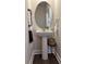 Stylish powder room with a pedestal sink, round mirror, and decorative fixtures at 14312 Crimson Ave, Bradenton, FL 34211