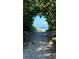 Scenic view through a natural archway of foliage leading to a sandy beach and the ocean on a sunny day at 14312 Crimson Ave, Bradenton, FL 34211
