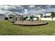 Community playground with swings, slides, and play structures surrounded by a grassy area and neighborhood homes at 14312 Crimson Ave, Bradenton, FL 34211