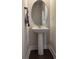 Pedestal sink and round mirror in a classic powder room, offering a clean and functional space at 14312 Crimson Ave, Bradenton, FL 34211