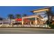 Exterior view of a modern shopping center, illuminated at dusk with palm trees and manicured landscaping at 14312 Crimson Ave, Bradenton, FL 34211