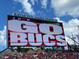 View of Raymond James Stadium's scoreboard displaying 'Go Bucs' amidst a crowd and pirate-themed decor at 14312 Crimson Ave, Bradenton, FL 34211