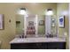 Bathroom features double granite vanity with black fixtures and a bedroom is reflected in the mirror at 1610 Bayshore Dr, Terra Ceia, FL 34250