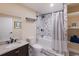 Modern bathroom with marble tile, dark fixtures, a shower-tub, and storage shelving at 1610 Bayshore Dr, Terra Ceia, FL 34250