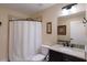Bathroom featuring granite countertops, dark cabinetry, framed mirrors, and shower with curtain at 1610 Bayshore Dr, Terra Ceia, FL 34250