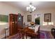 Formal dining room featuring an antique cabinet, ornate table, chandelier, and a picturesque window view at 1610 Bayshore Dr, Terra Ceia, FL 34250