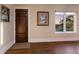 Neutral entryway featuring a dark wood door, hardwood floors, and sunset views through the window at 1610 Bayshore Dr, Terra Ceia, FL 34250