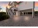 Elevated waterfront home showing the support beams, driveway, and a staircase leading to the main level at 1610 Bayshore Dr, Terra Ceia, FL 34250