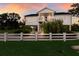 Charming two-story waterfront home featuring a white picket fence, lush landscaping, and elevated construction at 1610 Bayshore Dr, Terra Ceia, FL 34250