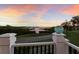 Balcony view of waterfront property with views of nature, shrubbery, waterway, and vibrant sunset at 1610 Bayshore Dr, Terra Ceia, FL 34250