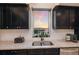 Kitchen window showcasing scenic water view with dark cabinets and stainless steel appliances at 1610 Bayshore Dr, Terra Ceia, FL 34250