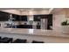 Modern kitchen featuring dark cabinets, stainless steel appliances, and a large granite countertop at 1610 Bayshore Dr, Terra Ceia, FL 34250