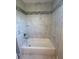 This bathroom features a tub with stylish marble-like tile surround and updated fixtures at 185 Wood Dove Ave, Tarpon Springs, FL 34689