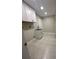 Functional laundry room with sink, white cabinets, and tile floor at 185 Wood Dove Ave, Tarpon Springs, FL 34689