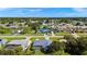 An aerial neighborhood view featuring a home with a screened pool surrounded by lush trees and greenery at 19897 Midway Blvd, Port Charlotte, FL 33948
