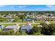An aerial neighborhood view featuring a home with a screened pool surrounded by lush trees and greenery at 19897 Midway Blvd, Port Charlotte, FL 33948