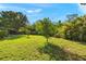 Expansive backyard with lush greenery, mature trees and space for outdoor activities at 19897 Midway Blvd, Port Charlotte, FL 33948