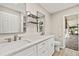 Bathroom with double sinks, modern fixtures, white cabinetry, and access to patio at 19897 Midway Blvd, Port Charlotte, FL 33948