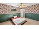 Bedroom with patterned wallpaper, green wainscoting, carpeted floors, and a ceiling fan at 19897 Midway Blvd, Port Charlotte, FL 33948
