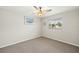 Bedroom with neutral tones, carpet, ceiling fan, and natural light from a window at 19897 Midway Blvd, Port Charlotte, FL 33948