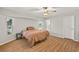Bright bedroom with hardwood floors, a ceiling fan and natural light through large windows at 19897 Midway Blvd, Port Charlotte, FL 33948